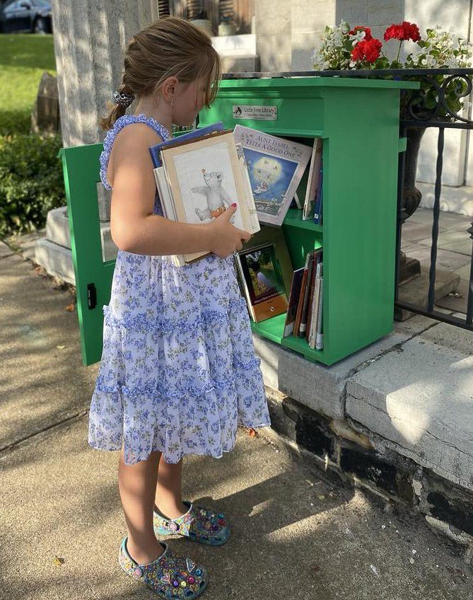 The Little Falls Historical Society’s Take a Book - Leave a Book “Little Green Library” being filled with books by Michael’s granddaughter, Eleanor